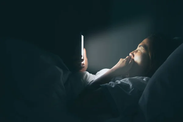 Asian woman play smartphone in the bed at night,Thailand people