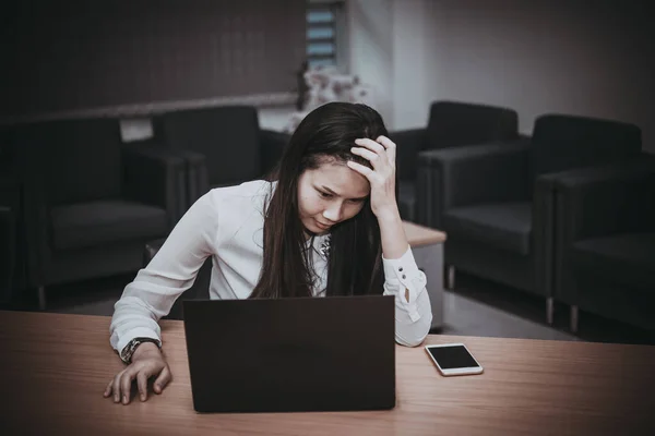 Businesswomanman stress from hard work on the desk at office dark tone,thailand people