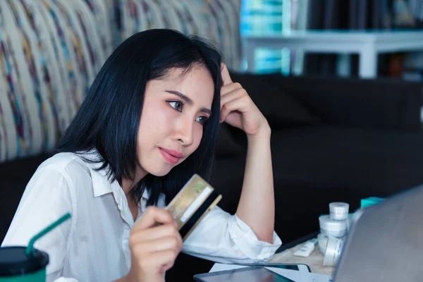 Beautiful asian woman working at home with stress