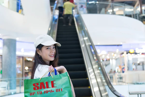 Asian hippie girl shopping in the Department store,Happy woman with shopping bags in hand in the shopping mall,thailand people,Ladies like to buy the best,Sale labels on shopping bag