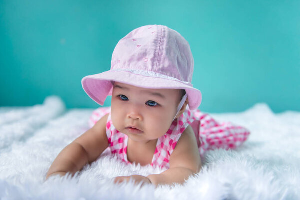 Portrait of cute asian baby in pink dress on carpet wool,happy baby concept,smile,thail little baby