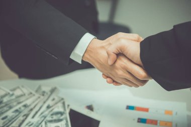 Asyalı iş adamları el sıkışıyor, toplantıyı bitiriyor, görev tamamlandı, iki iş adamı gelecekte iş birliği yapmak için el ele tutuşuyorlar.