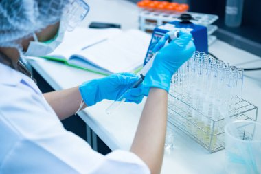 Asyalı bilim adamları plastik tüplere kimyasallar enjekte etti. Laboratuvarda çalışan Tayland 'lı bilim adamı. Laboratuvarda deneyler yaptı.