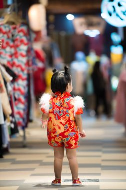 Cheongsam elbiseli, Taylandlı küçük Asyalı bir kızın portresi, mutlu Çin yeni yılı konsepti.