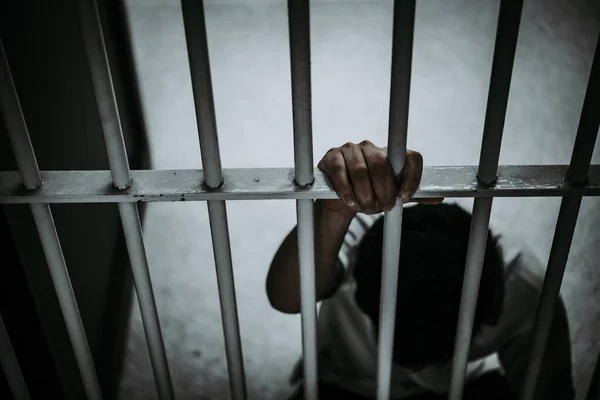 Demir hapishaneyi, esir konseptini, Tayland halkını yakalamak için çırpınan adamın elleri..