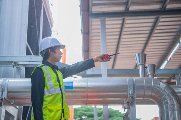 Asian Maintenance engineer at the waste water management system of a huge factory,maintenance checking technical data of heating system equipment,Thailand people