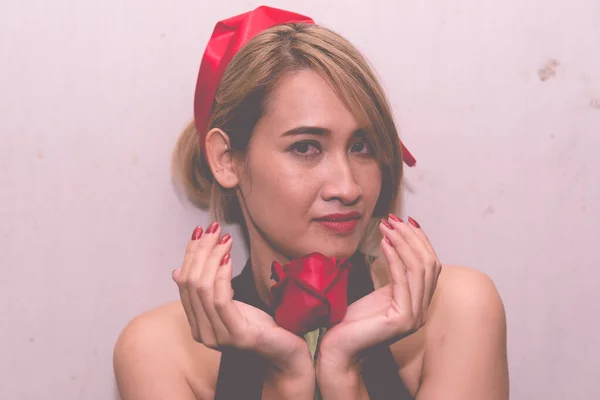 亚洲女人 红玫瑰手牵手 白墙背景 有选择的焦点 情人节观念 — 图库照片