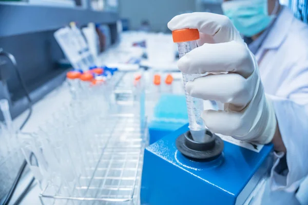 Bilim adamı deneyden önce kimyasalları sallama makinesiyle karıştırdı. Laboratuvarda çalışan Tayland 'lı bilim adamı test tüplerine numuneler karıştırdı.