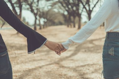 Asyalı bir çiftin el ele tutuşurken çekilmiş fotoğrafı.