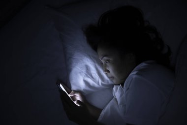 Asyalı kadın gece yatakta akıllı telefon çalar, Taylandlılar...