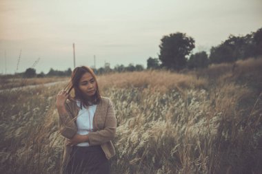 Tarlada yapayalnız bir kadının portresi. Klasik filtre stili. Aşktan kalbi kırık, günbatımı tarzında üzgün kız konsepti.