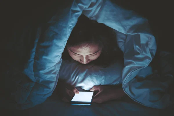 Asian woman play smartphone in the bed at night,Thailand people