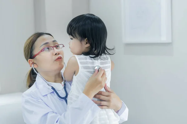 Asian doctor using a stethoscope to check his breathing and heart of a lovely girl, check the health of children,Thailand people