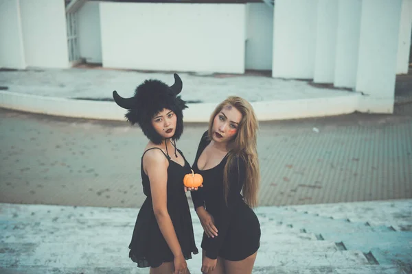 两个穿着黑色连衣裙的性感女孩从后面 黑色和白色 深色这两个概念之间穿行户外光圈 — 图库照片