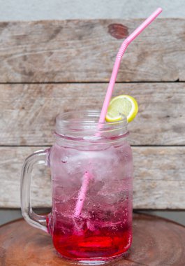 Ahşap zemin üzerinde limonlu kırmızı su karışımı soda, köpüklü