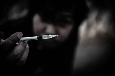 Asyalı adam siyah başlıklı umutsuz uyuşturucu bağımlısı, aşırı dozda uyuşturucu bağımlısı ve bilinç kaybı uyuşturucu ölüme, Taylandlılara, kan damarlarına eroin enjekte etmeye neden oluyor.