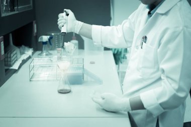 Bilim adamı deneyden önce kimyasalları sallama makinesiyle karıştırdı. Laboratuvarda çalışan Tayland 'lı bilim adamı test tüplerine numuneler karıştırdı.