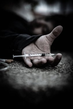 Asyalı adam siyah başlıklı umutsuz uyuşturucu bağımlısı, aşırı dozda uyuşturucu bağımlısı ve bilinç kaybı uyuşturucu ölüme, Taylandlılara, kan damarlarına eroin enjekte etmeye neden oluyor.