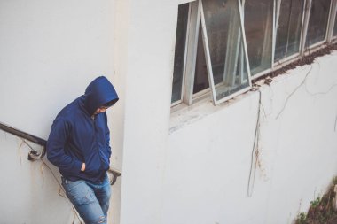 Asyalı üzgün bir adamın portresi, yerde oturan uyuşturucu bağımlısı, flakka ilacı, zombi uyuşturucusu