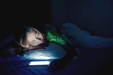 Asyalı kadın gece yatakta akıllı telefon oynuyor, Taylandlılar, sosyal medya bağımlısı, bütün gece internet oynuyor.