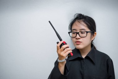 Asian engineer woman wearing glasses,using radio communication on white background,thailand technician use walkie talkie for work clipart