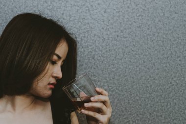 Asyalı bir kadının kalbi kırık, elinde viskiyle klasik tarzda, aşktan kırılıyor, üzgün kadın konsepti.