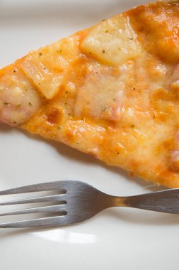 Beyaz tabakta çatallı yakın plan pizza.