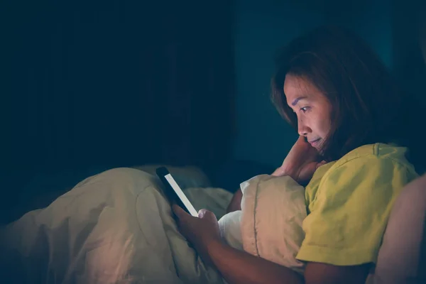 Asian woman play smartphone in the bed at night,Thailand people,Addict social media,Play internet all night