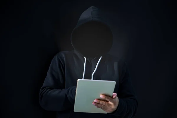 Asian hacker in black hood on black background
