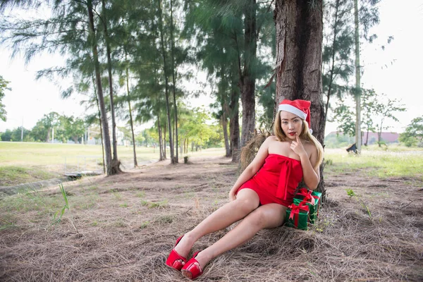Сексуальна Дівчина Санта Сидить Під Сосновим Деревом Розміщуючи Фотографії — стокове фото