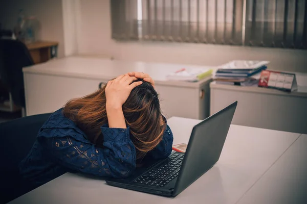 young business woman stressed from work overload while working in office