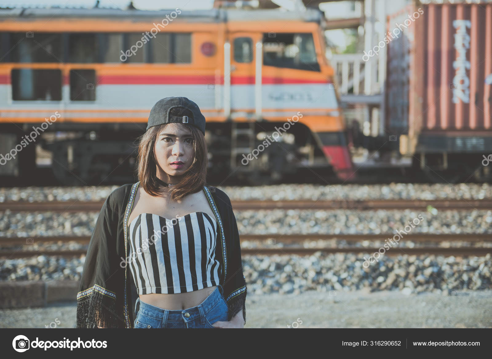 Photo of a man sitting on train tracks with a defiant pose Stock Photo -  Alamy