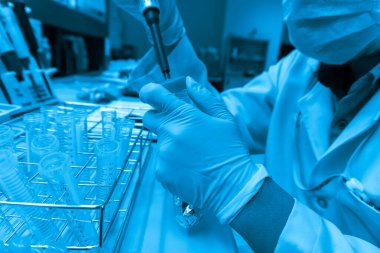 Bilim adamı deneyden önce kimyasalları sallama makinesiyle karıştırdı. Laboratuvarda çalışan Tayland 'lı bilim adamı test tüplerine numuneler karıştırdı.