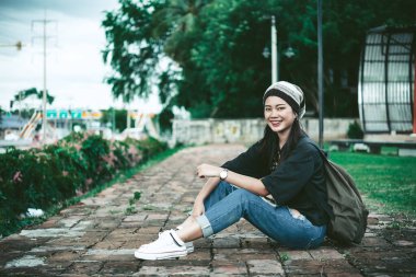 Güzel hippi kız, parkta rahatlamak bekâr bir kadının yaşam tarzı sırt çantalı Asyalı insanların portresi.