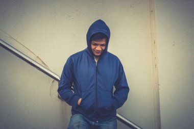 Asyalı üzgün bir adamın portresi, yerde oturan uyuşturucu bağımlısı, flakka ilacı, zombi uyuşturucusu