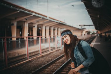 Asyalı turist tren istasyonunda bekler, Taylandlı hippi gezmeye gider.