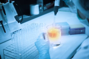 Asyalı bilim adamları plastik tüplere kimyasallar enjekte etti. Laboratuvarda çalışan Tayland 'lı bilim adamı. Laboratuvarda deneyler yaptı.