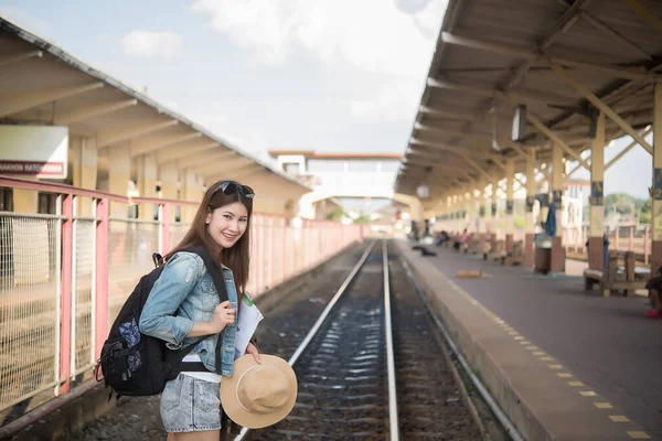 Asian tourist wait train at train station,thailand hipster womanman go to travel,Have a camera in hand