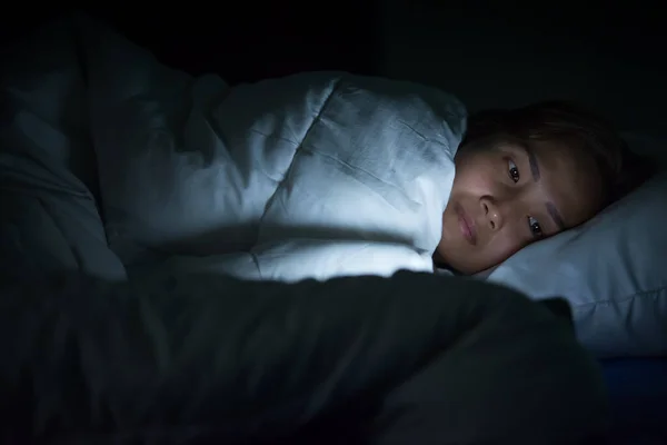 Asian woman play smartphone in the bed at night,Thailand people