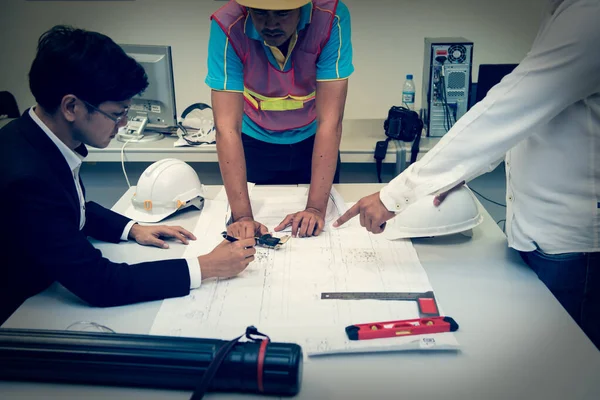 Tres Ingenieros Asiáticos Que Buscan Plano Papel Del Edificio Discuten — Foto de Stock