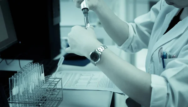 Scientist mix chemicals make experiment in the lab.Mixture laced with samples into test tubes,Thailand scientist working in the lab