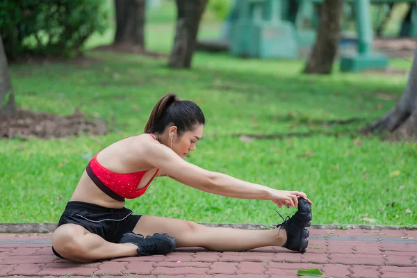 Asian sporty woman stretching body breathing fresh air in the park,Thailand people,Fitness and  exercise concept,Jogging in the park