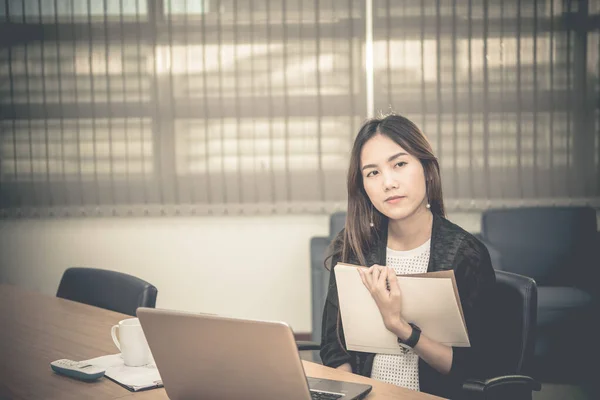 Asian businesswoman stress from hard work,Thai worker woman working in the office,Dark tone,holding file