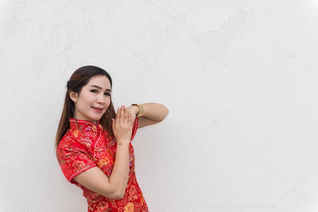 Asian woman in cheongsam on white wall, Happy Chinese new year concept