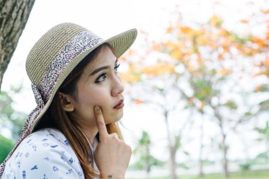 Dışarıda gülümseyen güzel bir kadın. Arka planda parlak güneş ışığı var.