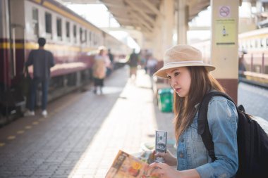 Asyalı turist tren istasyonunda bekler, Taylandlı hippi gezmeye gider.