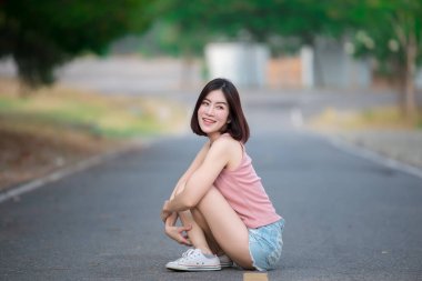 Asyalı kadın portresi yolda oturur, güzel Tayland halkı, mutlu kadın konsepti, modern kız yaşam tarzı...