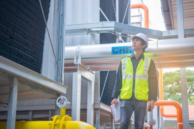 Büyük bir fabrikanın atık su yönetim sisteminde Asya Bakım Mühendisi, Tayland 'daki ısıtma sistemi ekipmanlarının teknik verilerini kontrol ediyor.