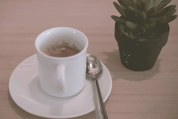 Hot coffee for service customer on wood table vintage style,dark tone,film,pastel,selective focus