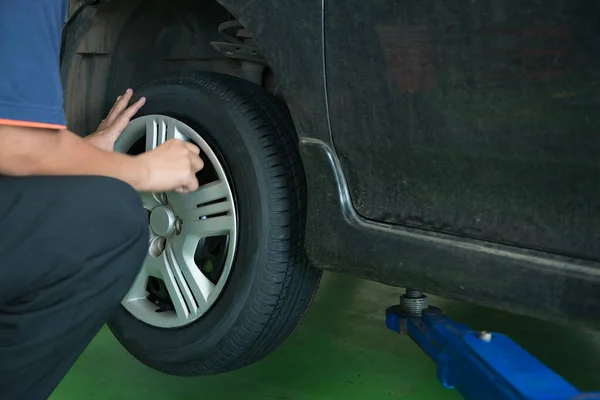 Technician change tire in the garage,According to the maintenance phase,Check problem of a car